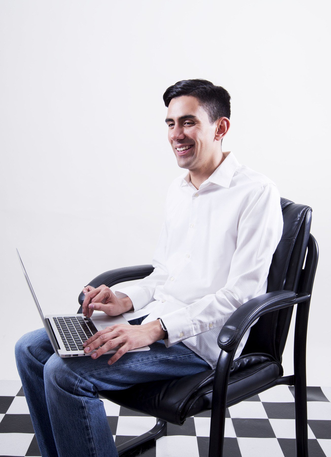 Emmanuel Meraz sonriendo, trabajando en su laptop